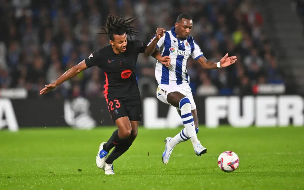 Real Sociedad's Sheraldo Becker struggling with FC Barcelona's Jules Koundé